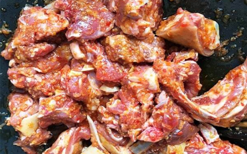 Trộn thịt với các loại gia vị trong tô lớn